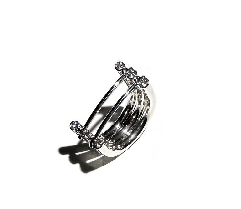 Silver ring with multiple bands on a white background
Polished sterling silver, swiss cut cz
Measures 7/16" wide