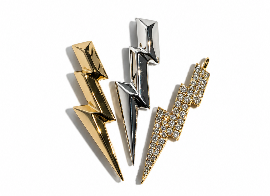 Three lightning bolt-shaped pendants arranged vertically on a plain white background. The left pendant is gold-toned, the middle is silver-toned, and the right earring is gold-toned with small diamonds set into its surface.