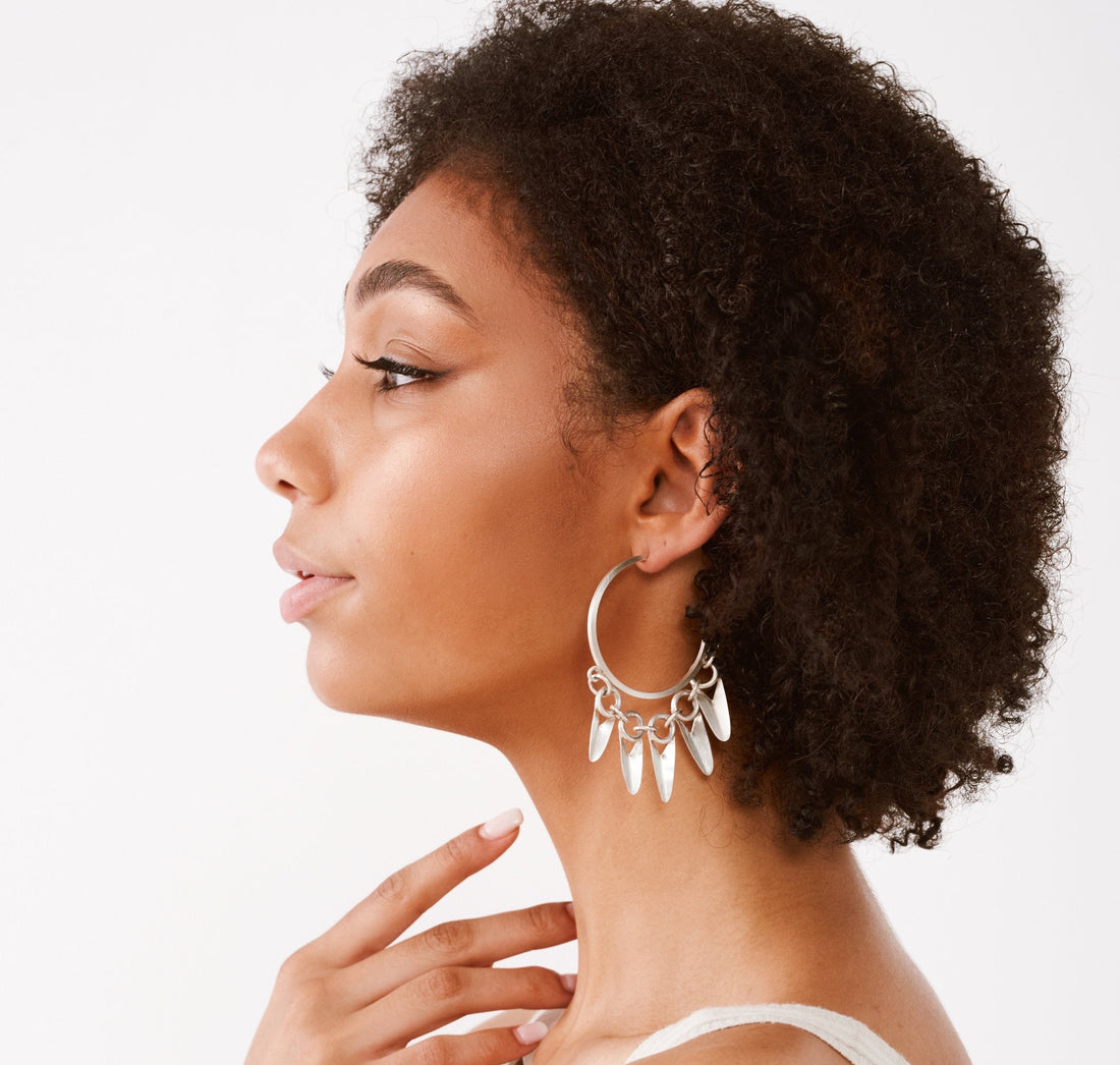 Silver hoop earrings with spike-like / leaf-like designs on model

Brushed sterling silver

Measures 1 3/4" across, longest petal measures 1 1/4"